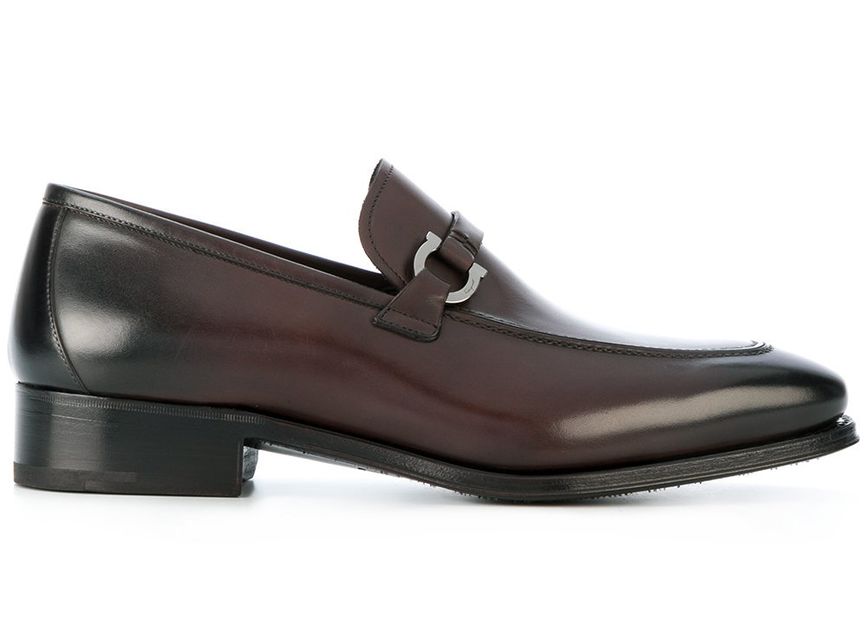 Salvatore Ferragamo предлагают более строгую модель лоферов темно-коричневого оттенка с U-образной пряжкой к деловому стилю.