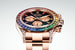Rolex. Cosmograph Daytona Rainbow. Корпус из розового золота диаметром 40 мм. Часовые указатели на циферблате выложены 11 сапфирами, цвет которых перекликается с цветом камней на безеле. 56 бриллиантов