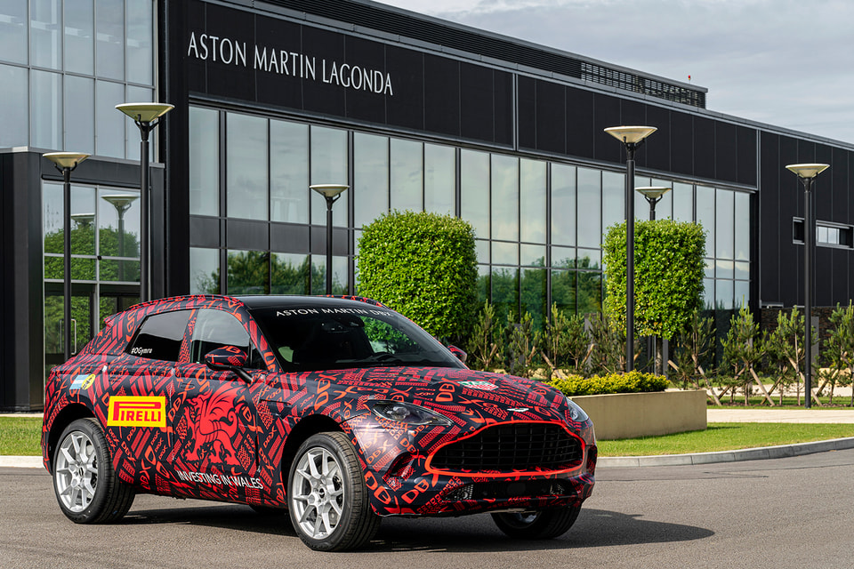 Внедорожник Aston Martin DBX на фоне завода в Сент-Атане