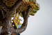 Скульптурная фигурка русалки исполнена из белого и желтого золота, ее хвост декорирован перегородчатой эмалью, а гребень и браслет усыпаны рубинами